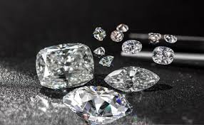 Brilliant cut diamonds arranged on a price evaluation sheet with tweezers